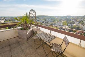 un balcon avec deux chaises et une plante dans l'établissement Le Bloy - Grande terrasse, Proche Paris, à Fontenay-aux-Roses