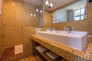 a bathroom with a sink and a mirror at Hôtel et SPA du Château in Lagord