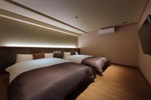 Rúm í herbergi á Marukyu Ryokan