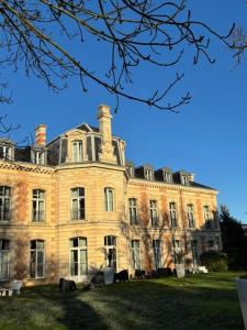 a large brick building with chimneys on top of it at Hôtel et SPA du Château in Lagord