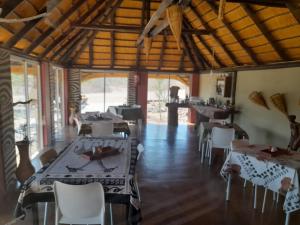 a restaurant with tables and chairs in a room at Hais Ra Tented Campsite in Khorixas