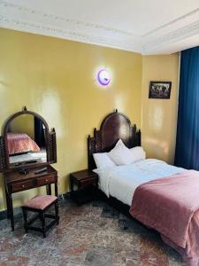 a bedroom with a bed and a table and a mirror at HOTEL AL MAMOUN in Casablanca