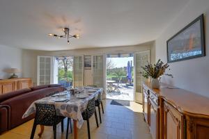 a dining room with a table and a couch at Ty Nehue - Maison avec jacuzzi in Crach