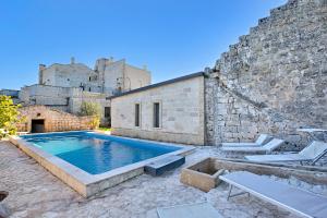 basen przed budynkiem z cegły w obiekcie Masseria Antoglia Rooms w mieście Villa Castelli