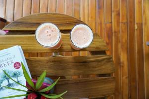 two drinks sitting on a wooden stand next to a plant at Sueño Río Celeste Boutique B&B in Bijagua +158 photos