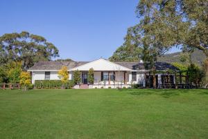 a white house with a large yard at La Roseraie - Elegant Hunter Valley Vines Homestead in Pokolbin