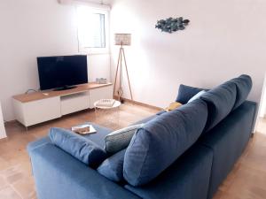 ein blaues Sofa im Wohnzimmer mit einem TV in der Unterkunft Beach Apartment Terrace in Vilamoura