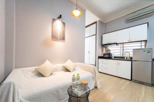 Un dormitorio con una cama y una mesa con botellas. en Convinia - Free Pick Up, en Ho Chi Minh