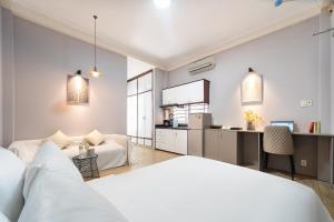 Un dormitorio con una cama y un escritorio en una habitación. en Convinia - Free Pick Up, en Ho Chi Minh
