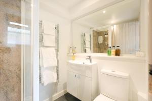 a white bathroom with a toilet and a sink at Berwick House in Sidmouth +17 photos