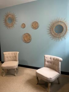 a room with two chairs and mirrors on the wall at Onyx Grey in Saint-Aignan +1 photo