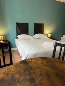a bedroom with two beds with white sheets and a table at Onyx Grey in Saint-Aignan