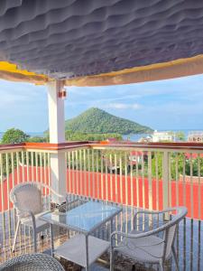 a table and chairs on a balcony with a view of the ocean at M'Pai Bay 23 Ripples Guesthouse and Sky Bar in Koh Rong Sanloem