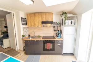 una cucina con lavello e frigorifero di SPACIEUX Appart Jacuzzi Terrasse Parking 10min port d'Honfleur Plage a Honfleur
