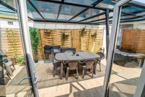 un patio con tavolo e sedie su un ponte di SPACIEUX Appart Jacuzzi Terrasse Parking 10min port d'Honfleur Plage a Honfleur