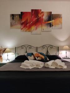 a bed with three towels and paintings on the wall at Funtana Meiga - Marina Breeze 50mt from sea in Funtana Meiga