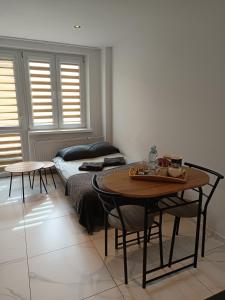 a bedroom with a bed and a table and chairs at Trzy Korony Apartament in Nowy Sącz