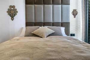 a bedroom with a large bed with a large headboard at Apartament JOA in Zakopane