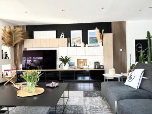 un salon avec un canapé et une table dans l'établissement Belle maison spacieuse et jardin paysager, Gouesnac'h, à Gouesnach