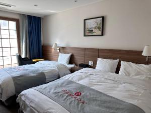 Postel nebo postele na pokoji v ubytování Ramada Taebaek Hotel
