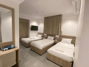 a hotel room with two beds and a television at فندق اليسر الفضي ام القري in Mecca