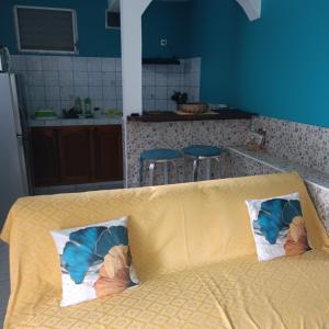 a couch in a kitchen with two pillows on it at LE MANGUIER in Le Gosier +1 photo