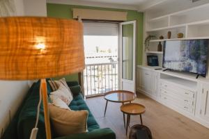 a living room with a couch and a television at Apartamento The River in El Puerto de Santa María
