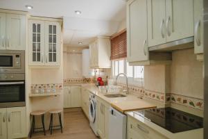 a kitchen with white cabinets and a sink at Apartamento The River in El Puerto de Santa María