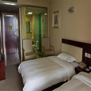 a hotel room with a large bed and two chairs at Ramada Encore by Wyndham Wuhan Int'l Conference Center in Wuhan