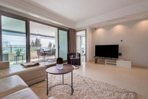 a living room with a couch and a tv at Luxury apartment in Jardines del Principe in Marbella