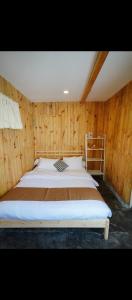 a bedroom with a large bed in a wooden wall at Kala Cabin Classic in Bongkor 1