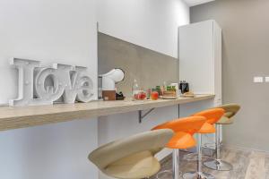 a kitchen with two orange chairs and a counter at Marconi APT per Famiglie - 20 Min dal centro in Rome