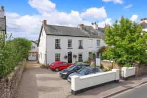a white house with cars parked in front of it at Berwick House in Sidmouth