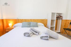 een slaapkamer met een wit bed met handdoeken erop bij House Beach Park in La Herradura