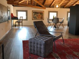 Una sala de estar con una silla y una mesa. en Il Re Della Cantina Appartamenti, en Crocetta del Montello