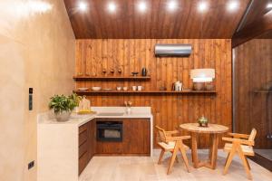 a kitchen with a table and a wooden wall at Erdőszéle Mátra in Parád