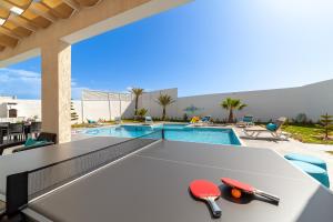 eine Tischtennisplatte vor einem Swimmingpool in der Unterkunft Dar Meryem Villa piscine sans vis-à-vis Djerba in Midoun