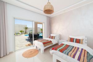 ein Schlafzimmer mit zwei Betten und Blick auf den Pool in der Unterkunft Dar Meryem Villa piscine sans vis-à-vis Djerba in Midoun + 6 Fotos