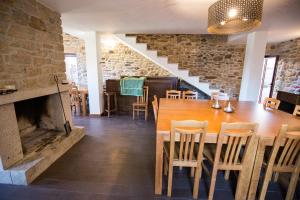 a dining room with a table and a fireplace at Casa Mirandês Rural in Miranda do Douro