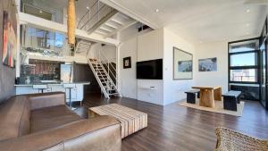 una sala de estar con un sofá y una mesa en Manhattan Lofts, en Ciudad del Cabo