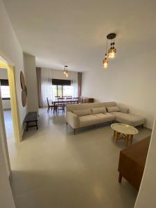 a living room with a couch and a table at Modern 2BR in Trendy Jabal AlWebdeh with View in Amman