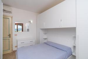 biała sypialnia z łóżkiem i lustrem w obiekcie Sardegnaot vista mare piscina e spa w mieście Olbia +22 zdjęcia