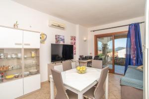 kuchnia i jadalnia z białym stołem i krzesłami w obiekcie Sardegnaot vista mare piscina e spa w mieście Olbia