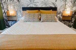 a bedroom with a large white bed with two lamps at Apartamento The River in El Puerto de Santa María