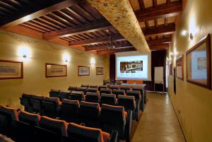 een collegezaal met stoelen en een projectiescherm bij Hotel Bologna in Pisa