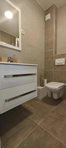 une salle de bain avec toilettes, lavabo et miroir dans l'établissement Opera Lux Apartments Green Hill - Modern Relaxing & Free Parking, à Sokobanja