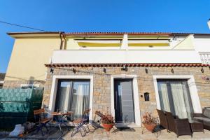 a brick house with two windows and a patio at AMB Apartmaji in Spodnje Škofije