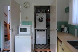 una cocina con lavadora y microondas en Ipharra, en Cadzand