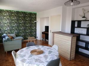 a living room with a table and a couch at La Nuit des Artistes - Spacious - Stade Toulousain in Toulouse
