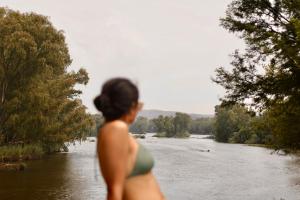 a woman in a bikini looking at a river at Breathe River Retreat in Parys